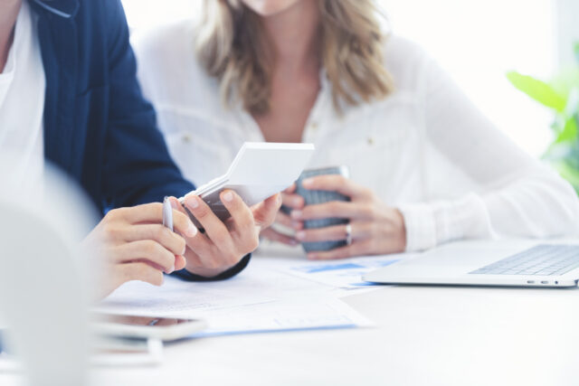 The image shows company directors analysing the numbers on their balance sheet.
