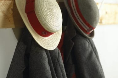 Private school hats and blazers hanging on wooden hooks